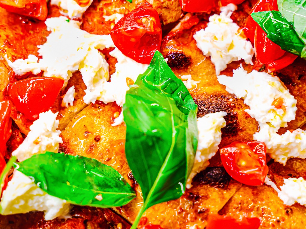 Cos'è la pizza al taglio, quali sono le sue origini, i segreti dell'impasto ad alta idratazione e i condimenti classici e creativi